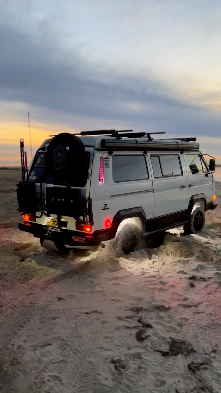 Rear view of Westfalia driving through sand